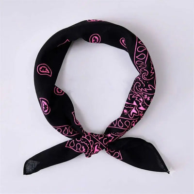 A black bandana scarf with a pink paisley pattern, tied in a knot and displayed on a light gray background.