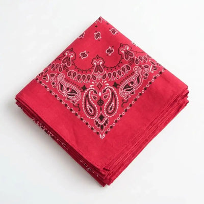 Folded red cowboy bandana with paisley pattern on a white background