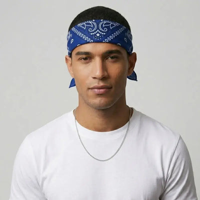 Man wearing a blue crip bandana and white shirt against a gray background