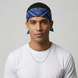 Man wearing a blue crip bandana and white shirt against a gray background